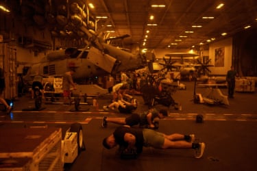 Sailors exercise in the hangar.