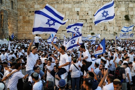 People at the Western Wall Plaza holding Israeli flags