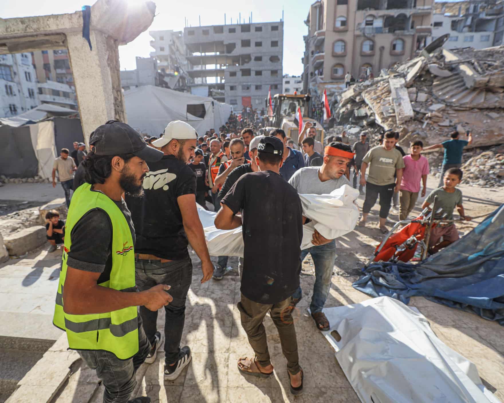 People carrying a body wrapped in a white sheet from the site of the catastrophe