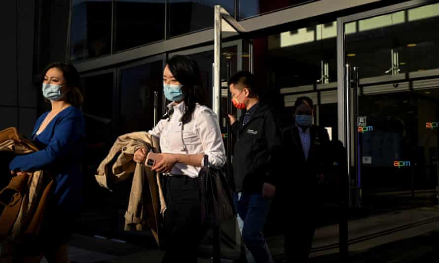 Žmonės išeina iš prekybos centro Pekine 2022 m. balandžio 15 d