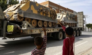 Children wave to a Turkish forces truck at the border with Syria in southeastern on Turkey.