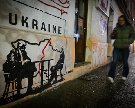 A mural titled ‘Divided by Oligarchy’ by anonymous Norwegian street artist Toddel, depicting US president Donald Trump and Russian president Vladimir Putin seated at a table next to a map of a divided Ukraine, is seen on a wall in Krakow, Poland.