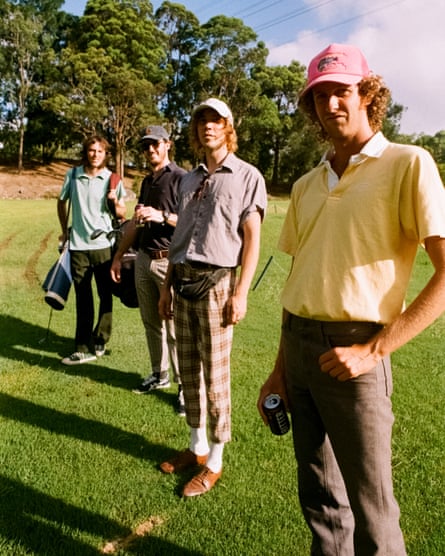 Band members in golf clothes on a golf course