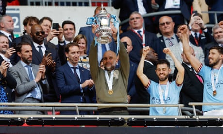Pep Guardiola lifts the FA Cup.
