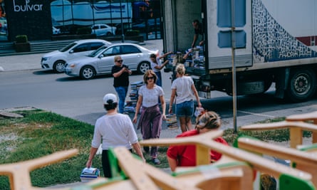 People carry books from a library and load them into the back of a truck