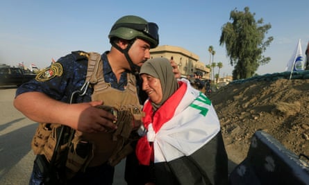 A member of Iraqi federal police kisses a resident of Mosul after ‘victory’ was declared over Islamic State.