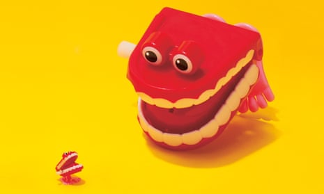 Little and large jokey false teeth against a yellow background