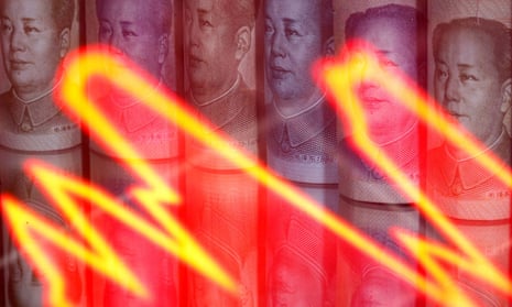 Chinese Yuan banknotes are seen behind an illuminated stock graph