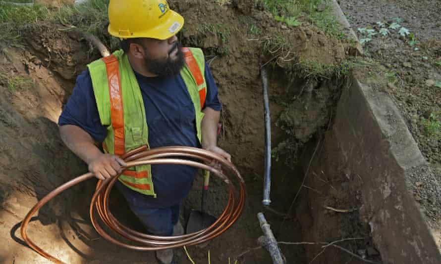 A worker in Denver, Colorado, installs a a new copper water service line.
