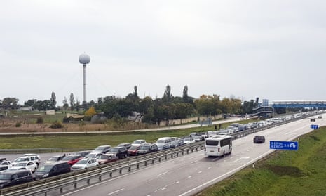 Vehicles wait to cross the bridge near Kerch in Crimea a day after the bridge was hit by an explosion