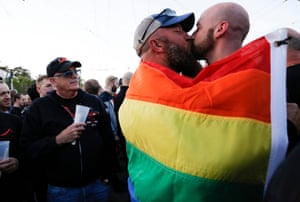 San Francisco, USA couple kiss under an LGBT pride flag at a remembrance ceremony in Castro