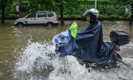 Person rides through the waterlogged in Shaoguan, Guangdong province.