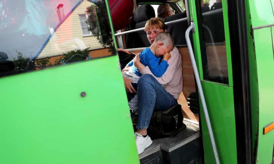 A woman comforts a child as they travel in the evacuation convoy.