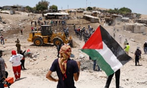 Palestinian demonstrators try to prevent an Israeli tractor from entering Khan al-Ahmar.