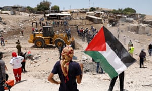 Palestinian protesters trying to prevent an Israeli tractor from entering Khan al-Ahmar