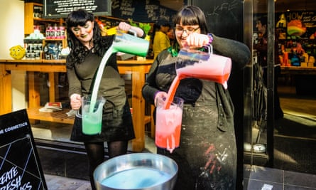 Two members of staff mix bath cosmetics outside a Lush shop