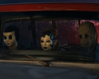 three people wearing white, drawn masks sit in car