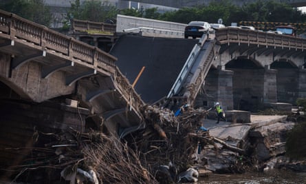 Workers inspect a bridge that collapsed in Beijing after a flash flood