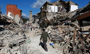 A man walks amidst rubble following an earthquake in Pescara del Tronto
