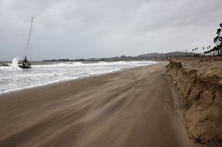 A wave hits a boat which washed ashore as a powerful long-duration atmospheric river storm, the second in less than a week, in Santa Barbara, California, on Sunday.