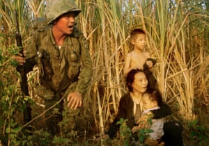 A soldier from the Republic of Korea beside a Vietnamese family north of Bong Sen, Vietnam, 1966