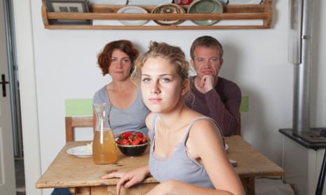 A young woman with her parents at the kitchen table
