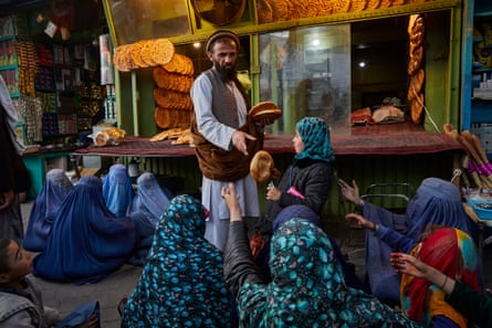 Women and children beg for bread outside a bakery in Kabul.