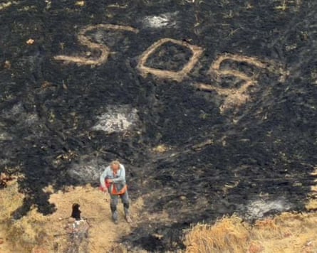 a man stands next to an SOS message