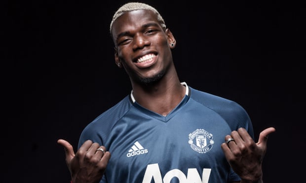 Paul Pogba poses after signing for Manchester United.
