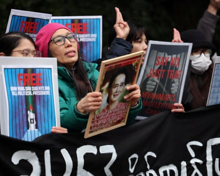 Women holding placards with images of Aung San Suu Kyi and the word ‘free’.