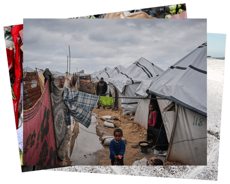 A woman cooks outside her flooded tent in a refugee camp