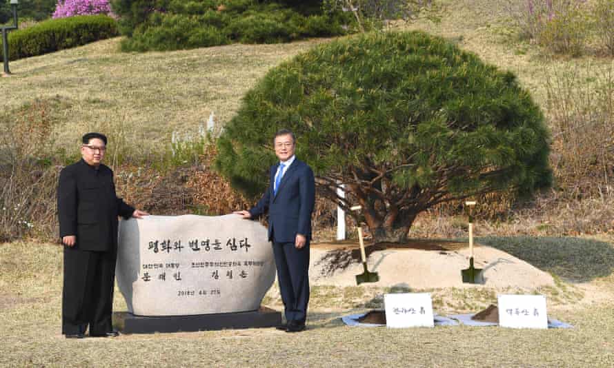 Kim Jong-un Moon Jae-in pose in front of a stone during a tree-planting ceremony.