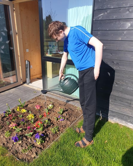 A young man waters plants at Linden Farm