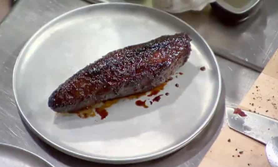 piece of burnt meat on a metal plate