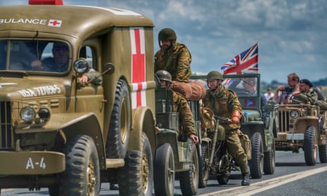 A convoy of military re-enactors in vehicles gather on the road to Arromanches, France.