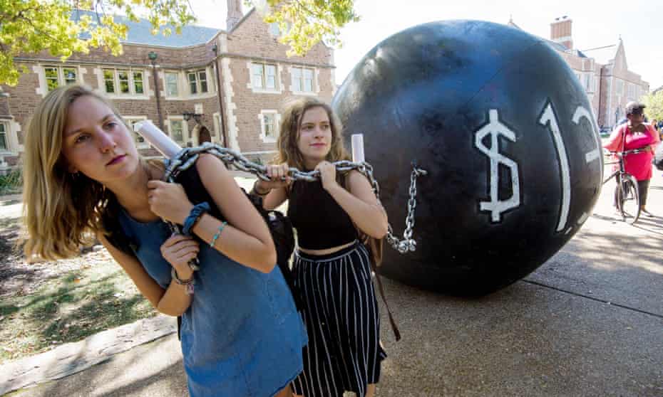 Students pull a mock ball and chain representing student debt, at Washington University in St Louis, Missouri.