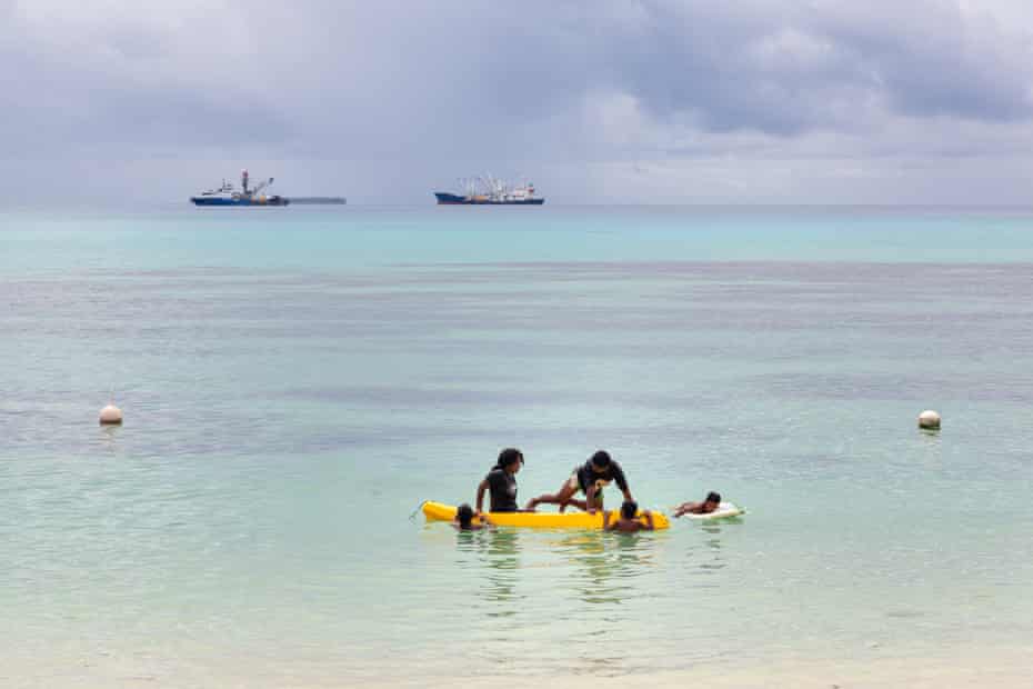 Children play in a small boat on the waters of the Funafuti lagoon