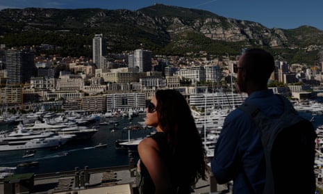 People look at yachts moored at the Hercules Port in Monaco.