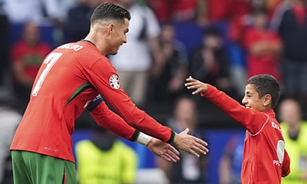 A kid takes a selfie with Cristiano Ronaldo during Portugal’s Euro 2024 match against Turkey.