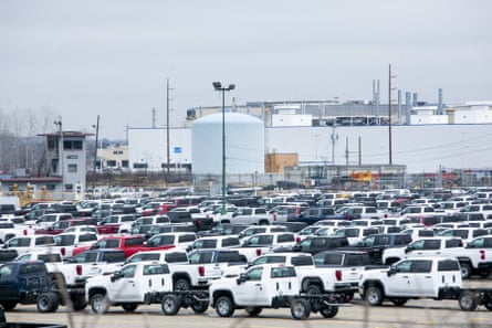 New vehicles sit in a lot in front of the idled General Motors Co at an assembly plant in Flint, Michigan, in 2020.