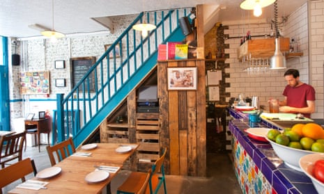 The wooden tables and blue staircase in Santa Remedio in London’s Shoreditch.