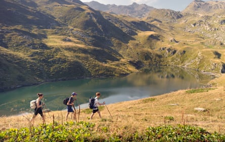 Mum and two sons walking in the mountains above a lake