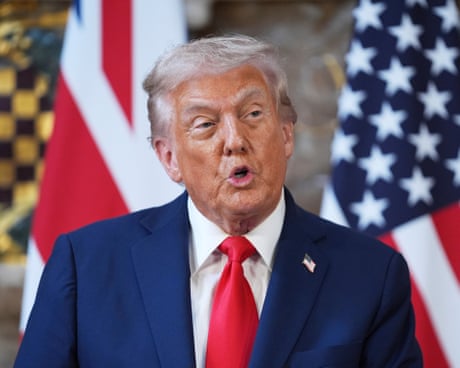 Man speaks in front of flags
