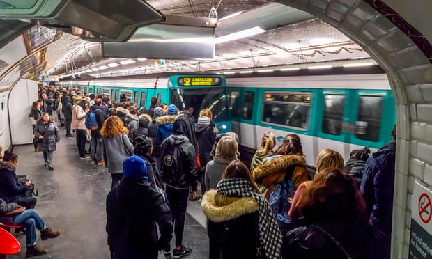 Passengers wait on a Paris metro platform