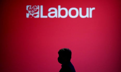 A person walks past the logo of the Labour party during the annual conference in Brighton