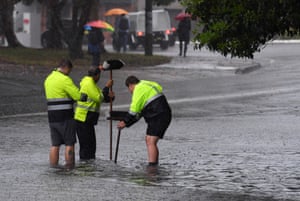 Council workers clear a drain on Railway Terrace in Lewisham during wild weather in Sydney.