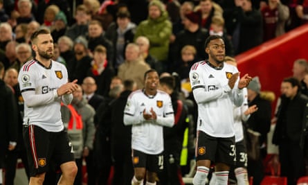 Luke Shaw en Anthony Elanga van Manchester United zwaaien naar reizende fans na hun pak slaag op Anfield