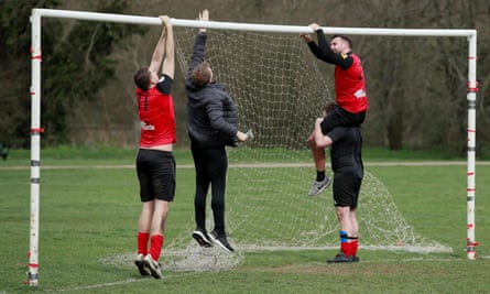 Football players set up goalposts in the park.
