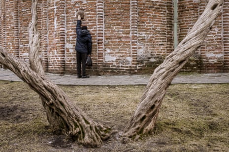 A man makes a wish touching an ancient stone in Saint Paraskevi's Church in Chernihiv.