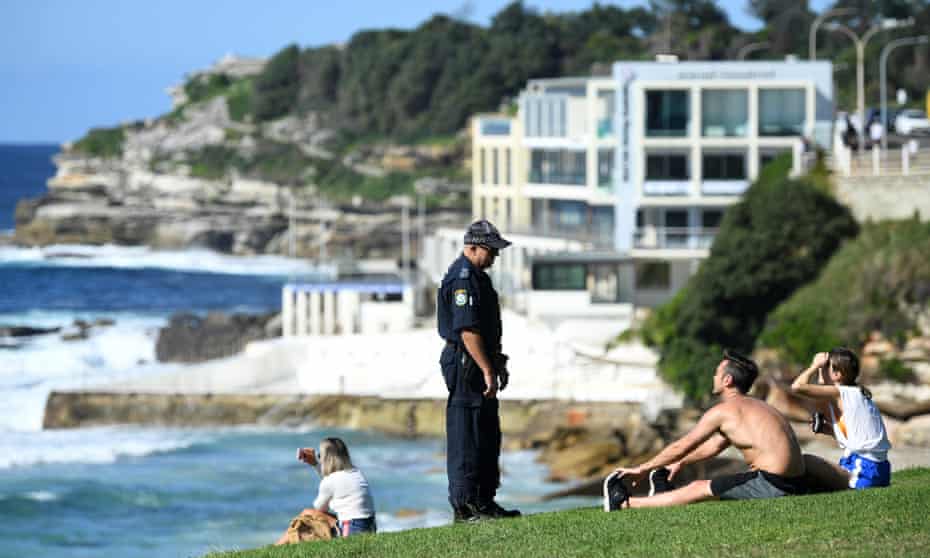 policeman asks people sitting down to move on